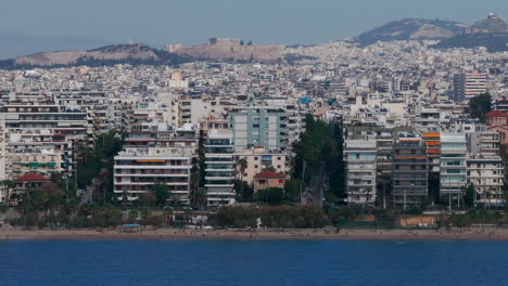 Tight-aerial-slider-shot-of-the-sea,-Athens-houses-and-the-Acropolis