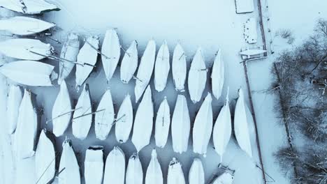 Top-view-yachts-lined-up-in-several-rows-and-covered-with-a-thick-layer-of-snow