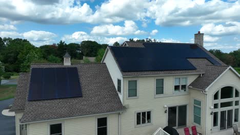 Large-house-with-solar-panel-arrays-on-shingle-roof