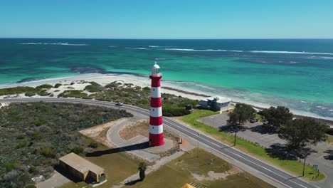 Red-and-white-lighthouse-on-coast-road-with-clear-turquoise-ocean---Geraldton,-Australia