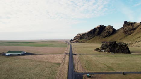 Cinematic-aerial-forward-vast-Iceland-panorama,-Drangurinn-old-wooden-hut