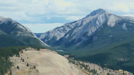 Eagle-Lake-nested-between-two-giant-rocky-mountains-is-seen-from-an-aerial-drone-point-of-view-in-the-Ya-Ha-Tinda-Ranch-area-of-Alberta-Canada