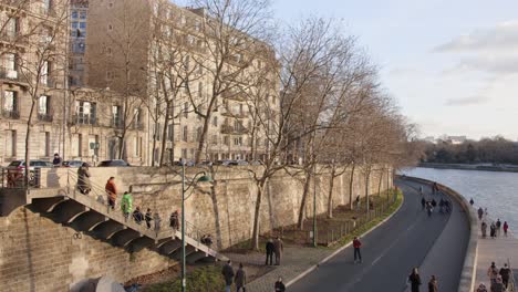 Seine-Riverbank-with-Pedestrians-Walking-and-Running-Leisurely-in-Paris,-France