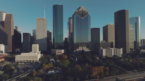 An-aerial-establishing-shot-pans-from-right-to-left,-capturing-the-late-afternoon-view-of-the-north-side-of-the-downtown-Houston-skyline-in-Houston,-Texas