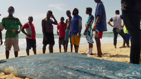 Hombres-Africanos-Reunidos-Alrededor-De-Pescado-Fresco-En-Una-Playa-De-Ghana.