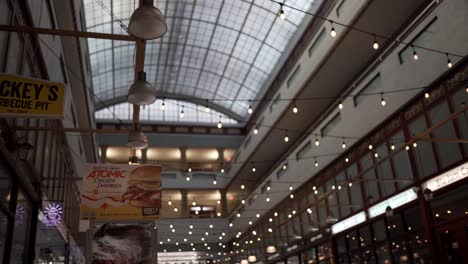 Arcade-mall-interior-with-huge-soft-skylight,-string-lights-and-signs-of-commerce