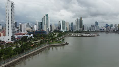 Langsamer-Panoramablick-Aus-Der-Luft-Auf-Die-Berühmte-Skyline-Der-Innenstadt-Von-Panama-City-Entlang-Der-Uferpromenade
