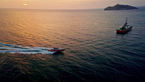 Close-up-aerial-drone-shot-of-boat-speeding-in-Santa-Marta-at-sunset-in-Colombia