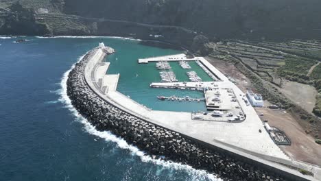Aerial-establishing-view-of-large-breakwater-protecting-port-of-Garachico,-Tenerife