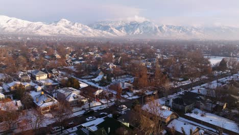 Snow-covered-houses-illluminated-by-sunlight-as-inversion-fog-layers-below-stunning-Wasatch-mountains-in-winter