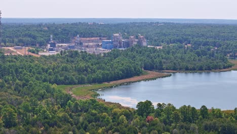 Moving-up-and-quickly-to-the-right-above-a-small-peninsula-and-a-large-lake-inlet-that-has-a-power-plant-behind-it