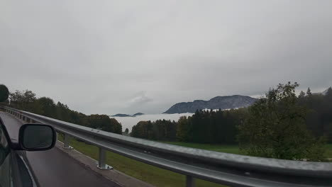 Ich-Schaue-Aus-Dem-Autofenster,-Während-Die-österreichischen-Alpen-über-Den-Wolken-Aufragen