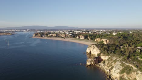 Aerial-establisher-large-beach,-Praia-Grande-in-Ferragudo,-Portugal,-summer-day