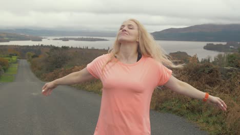 Joyful-Ukrainian-woman-twirling-in-front-of-scenic-lake-view