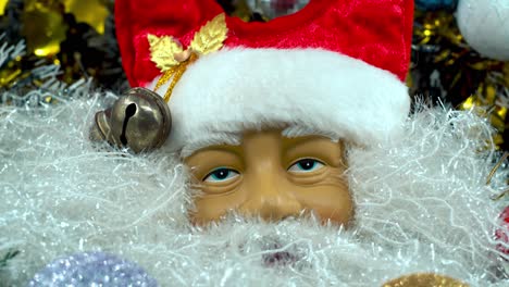 Weihnachtsmann-Spielzeug-Mit-Rotem-Hut-Und-Glocken,-Weihnachtsdekoration,-Traditionelle-Feiertagsgeschenke,-Neujahrsdekoration,-Glänzendes,-Farbenfrohes-Dekor,-Detaillierte-Nahaufnahme-Mit-Sanfter-Neigung,-4K-Video