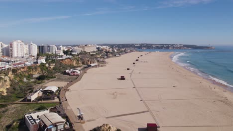 Large-empty-sand-beach-in-Portimao,-Portugal,-aerial-dolly-in-summer-day