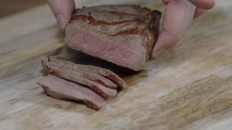 Chef-cutting-beef-steak-into-slices,-for-argentine-barbecue-with-chimichurri-and-cafe-de-paris-butter-sauce