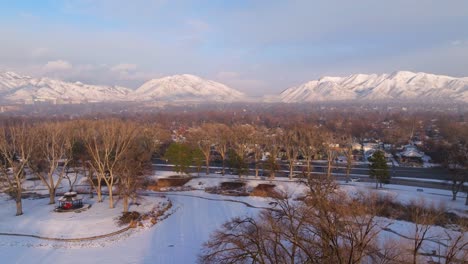 Ein-Schwarm-Möwen-Schwebt-Im-Schneebedeckten-Himmel-über-Dem-Liberty-Park-Mit-Den-Epischen-Canyons-Von-Utah-Im-Hintergrund-Im-Winter