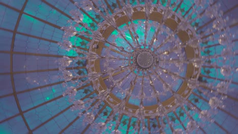 Spinning-image-of-an-etheric-multi-colored-glass-chandelier-in-the-celling-of-an-event-space