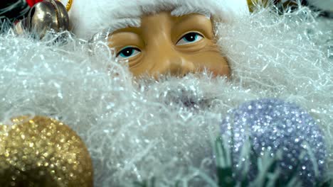 Detaillierte-Nahaufnahme,-Glatter-Schwenk-Nach-Links,-Weihnachtsmann-Spielzeug-Mit-Rotem-Hut-Und-Glocken,-Weihnachtsdekoration,-Traditionelle-Feiertagsgeschenke,-Neujahrsdekoration,-Glänzende-Bunte-Geschenke,-4K-Video