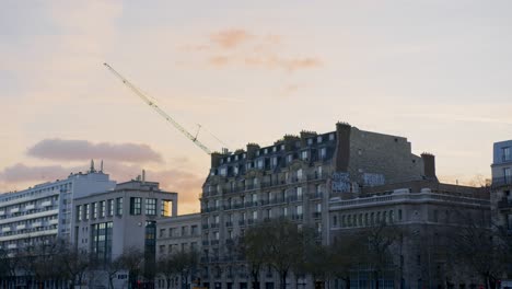 Pariser-Skyline-Mit-Kran-über-Haussmann-Gebäuden-Bei-Sonnenuntergang