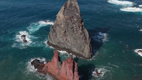 Rocas-En-Un-Hermoso-Océano-Azul-Con-Olas-Rompiendo-Creando-Espuma-Durante-El-Día-Soleado