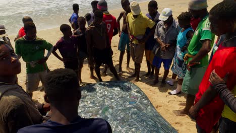 Glückliche-Afrikanische-Männer-Am-Strand-Mit-Einem-Fischernetz-Voller-Frischem-Fisch