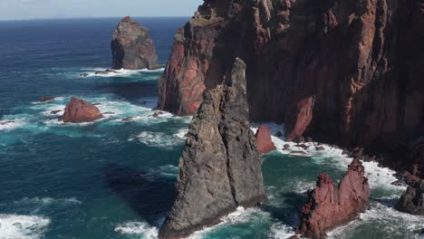 Felsen-Und-Klippen-Im-Wunderschönen-Blauen-Ozean-Mit-Wellen,-Die-An-Sonnigen-Tagen-Schaum-Erzeugen