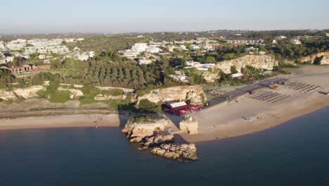 Scenic-sunrise-aerial-orbit-large-beach-praia-Grande-in-Ferragudo-Portugal
