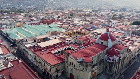 Aerial-shot-flying-over-red-domed-church-and-city-in-Oaxaca-de-Juarez---Mexico