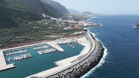 Panoramic-aerial-establishing-overview-Port-Garachico-with-sailboats-docked-in-marina