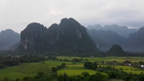 Malerische-Aussicht-über-Die-Felder-Von-Vang-Vieng-Mit-Bergen-Im-Hintergrund