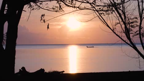 Lokales-Fischerboot,-Das-Während-Eines-Wunderschönen-Himmlischen-Sonnenaufgangs-Mit-Rosafarbenem-Himmel-Auf-Einer-Tropischen-Insel-In-Timor-Leste,-Südostasien,-Durch-Ein-Friedliches,-Ruhiges-Und-Friedliches-Meer-Fährt