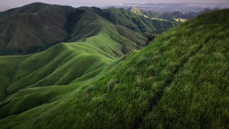 Aerial-forward-shot-of-Mount-Labawan-green-grassland-scenery-ridge-trail