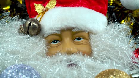 Weihnachtsmann-Spielzeug-Mit-Rotem-Hut-Und-Glöckchen,-Großer-Weißer-Bart,-Weihnachtsdekoration,-Traditionelle-Feiertagsgeschenke,-Neujahrsdekoration,-Glänzendes,-Farbenfrohes-Setup,-Kreative-Nahaufnahme-Mit-Langsamer-Neigung-Nach-Unten,-4K-Video