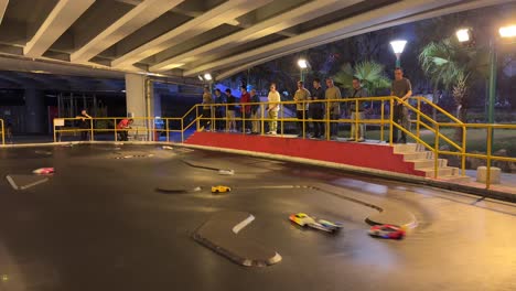 Adults-Racing-Toy-Cars-on-Small-Racing-Track-Under-a-Bridge-in-Hong-Kong