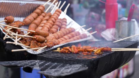 Preparing-street-food-in-Panama:-various-types-of-skewered-food-being-grilled,-with-sausages-and-marinated-meat