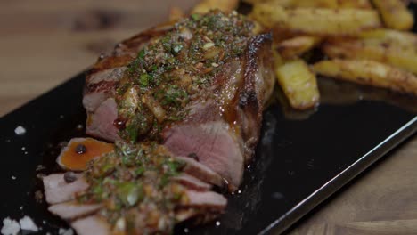 Grilled-beef-with-chimichurri-sauce-and-french-fries,-close-up