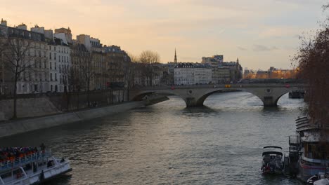 Tourist-Sightseeing-Boat-Sailing-on-the-Seine-River-at-Dusk-in-Paris,-France