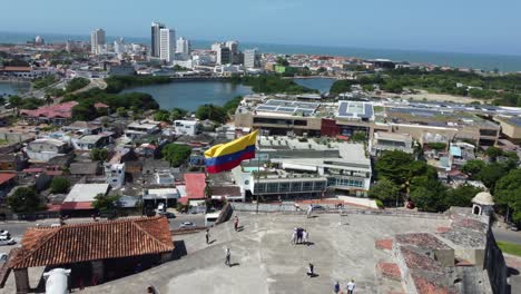 Turistas-Tomando-Fotos-Frente-A-La-Bandera-Colombiana-En-Cartagena,-Colombia