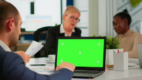 Rückansicht-Eines-Geschäftsmannes,-Der-Am-Konferenztisch-Sitzt-Und-Einen-Laptop-Mit-Grünem-Bildschirm-Benutzt