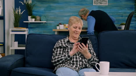 Happy-middle-aged-mature-woman-enjoying-using-mobile-apps-texting