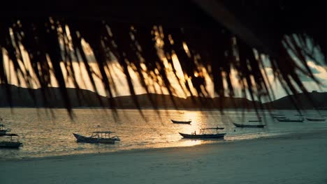 Kamerafahrt-Von-Booten-Am-Sandstrand-Bei-Sonnenuntergang-In-Indonesien