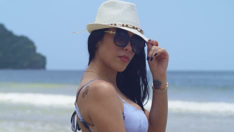 A-young-Latina-woman,-clad-in-a-bikini,-relishes-a-sun-filled-day-on-a-Caribbean-beach