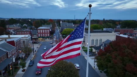 Bandera-Americana-Ondeando-En-Una-Pequeña-Ciudad-De-EE.UU.-Durante-El-Anochecer