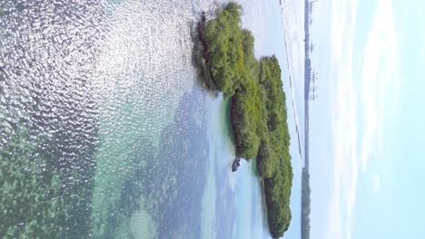Vertikalflug-über-Tropische-Landschaft-Mit-Grünen-Inseln-Und-Reflektierender-Sonne-Im-Wasser