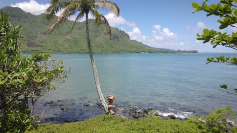 Im-Schatten-Einer-Palme-Ziert-Eine-Frau-In-Rosa-Bikini-Und-Strohhut-Einen-Hawaiianischen-Strand