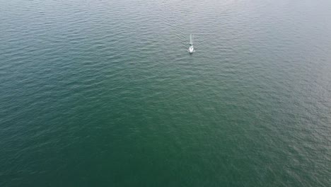 Static-drone-shot-of-sailboat-crossing-the-frame
