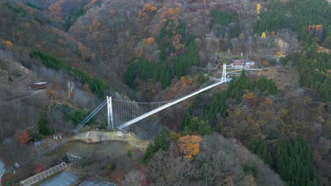 Aerial-drone-flight-over-high-above-suspension-bridge-in-Japanese-countryside