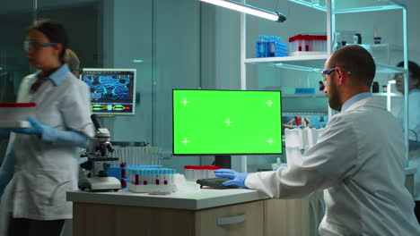 Scientist-man-typing-on-computer-with-green-mockup